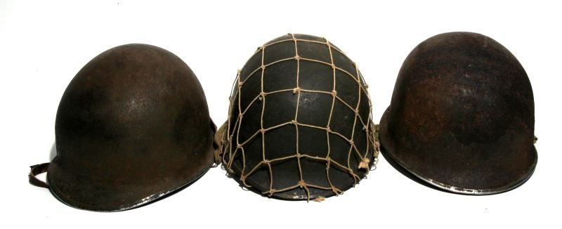 3 WWII - VIETNAM M1 FRONT SEAM SWIVEL BALE HELMETS: One has a 2 inch mesh khaki coloured cover, one olive drab painted helmet, one more olive drab painted with painted name on the inside. Condition varies from fair to good.