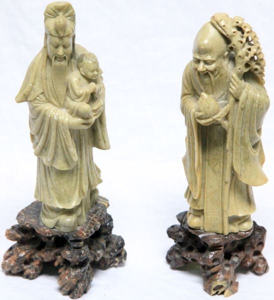 LOT OF TWO CHINESE SOAPSTONE FIGURINES: Chinese soapstone figural carvings, the first is Shou Lao holding a child; measures at 7.75 inches in height and 10.5 inches with the stand, the second depicting Shou Lao standing with a peach and gna