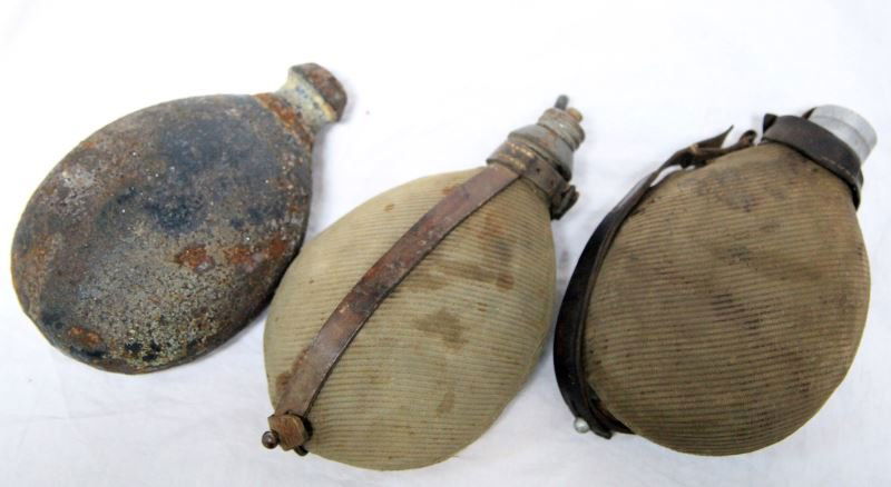 GROUP OF THREE WWI IMPERIAL GERMAN CANTEENS: One named to Diesfeld, also marked 1917, two with the corduroy and full body strap made of leather. One is in poor condition, the other two are in good condition.
