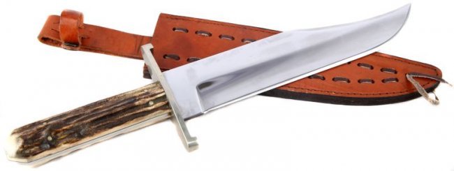 LARGE CLIP POINT BOWIE KNIFE STAG HANDLE: Large stag handle clip point Bowie knife. 10.25 inch blade, marked "D. RHEA" on ricasso. Steel guard, with polished stag grip scales. Light tan leather scabbard with retaining strap. This lot has a re