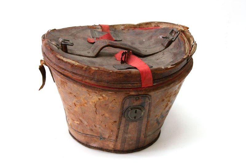 ENGLISH ANTIQUE LEATHER HAT BOX LATE 19TH CENTURY: English antique leather hat box, red cloth interior, late 19th Century. Original leather strap and clasp (closure) missing. Red elastic strap appears to have been added. Leather lid is severely cracke