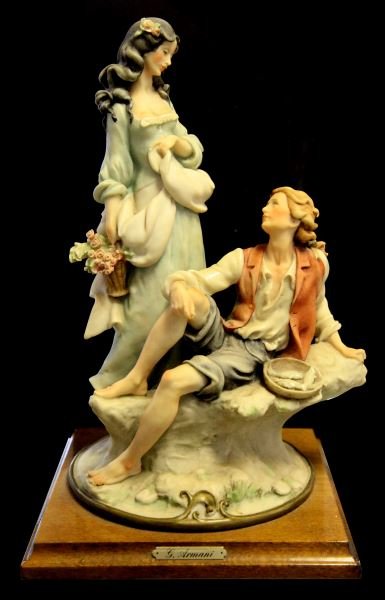 GIUSEPPE ARMANI STATUE OF GIRL WITH BOY AND FISH: Giuseppi Armani girl with flower basket and boy with fish, 14 inches tall and 8 inches wide with wood base. Figurine is marked with blue N and crown as well as artist's signature and also marked Flore