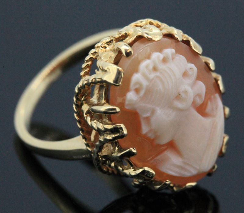 LADIES 10KT YELLOW GOLD CAMEO RING: Fancy gallery setting with rope trim work on sides, containing one oval shape shell cameo measuring 18 x 14mm.