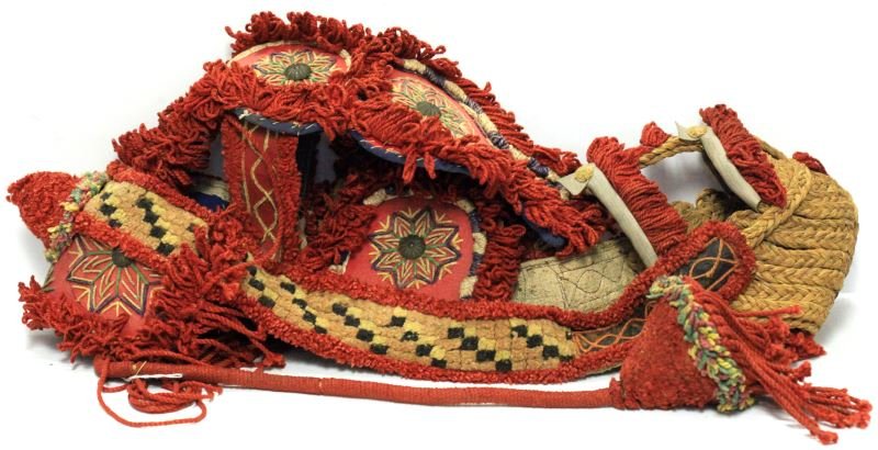 DECORATIVE YARN CLOTH CAMEL BRIDLE HEADDRESS: Vintage decorative yarn and cloth bridle/headdress with blinders, for camel or horse. Predominately red yarn decor, some embroidered design, blue cloth interior, and straw muzzle. No bit. Very good co