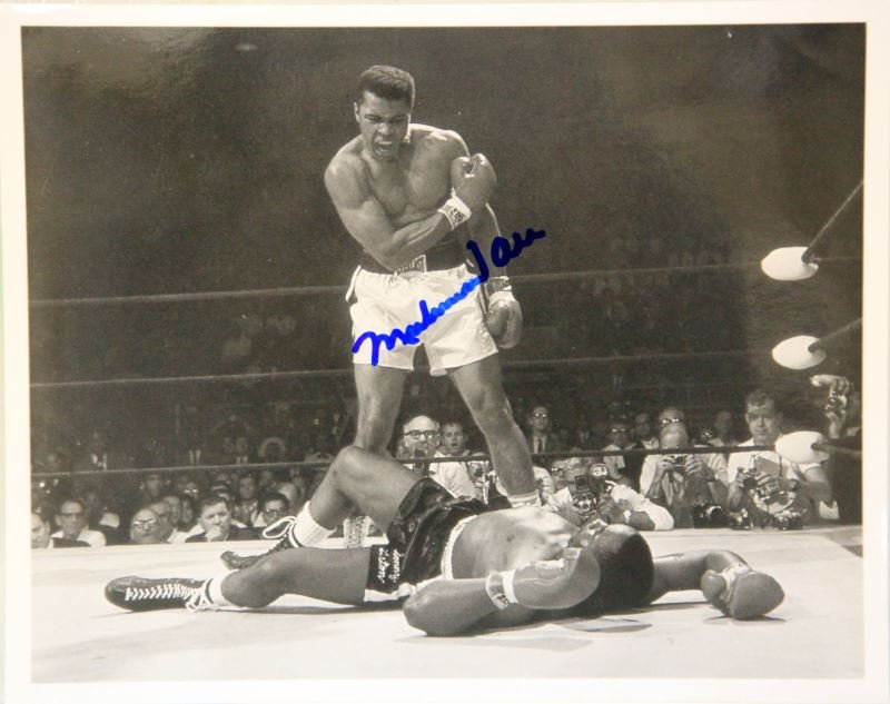 AUTOGRAPHED PHOTO OF MUHAMMAD ALI WITH COA: 8 by 10 inch autographed photo of heavyweight champion Muhammad Ali with a COA from Leo's Sports Memorabilia Room. In very good condition.