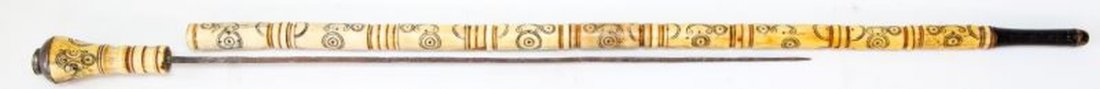 VINTAGE CARVED BONE CANE SWORD 4-SIDED BLADE: Vintage carved bone cane sword. Four-sided blade is made of iron and rust is present. Wood to bottom and brass surrounding pommel. Circular designs all over. Natural lines throughout. Measures 34 inch