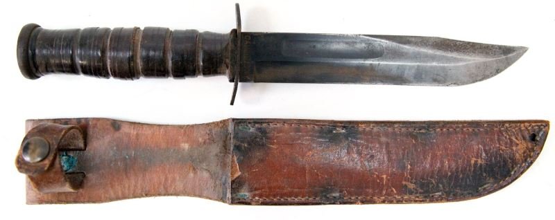 WWII CAMILLUS USMC FIGHTING KNIFE AND SHEATH: Good to very good condition. Some surface rust to blade and fittings. Some bluing remains to blade. Blade marked "Camillus N.Y." on ricasso and "U.S.M.C." on obverse. Leather washer grip. Unmarked lea