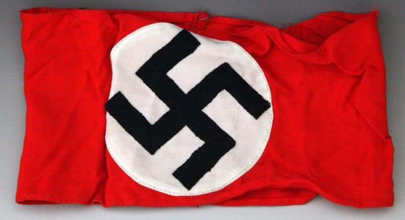 ORIGINAL 3 PIECE NAZI GERMANY SWASTIKA ARMBAND: Red field with white circle applied. Black ribbon Swastika is applied to that being folded at turns. Passes black light test. In very good condition with minor loose threads. This lot has a reserve.