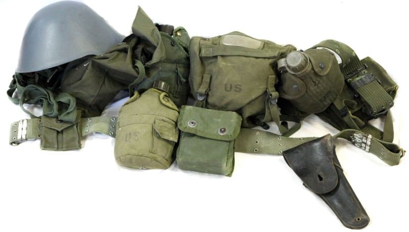 MILITARY GEAR LOT HELMET BELT CANTEEN HOLSTER: A grouping of somewhat married belts WWII to Vietnam gear, holster, Swiss helmet, socks and more.