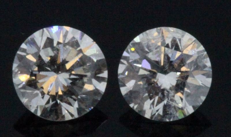 TWO ROUND BRILLIANT CUT DIAMONDS .96CT TW: Perfect stones for stud earrings; two round brilliant cut diamonds, each weighing .48cts, color graded G-H, both clarity enhanced. Both diamonds face up very pretty. This lot has a reserve.