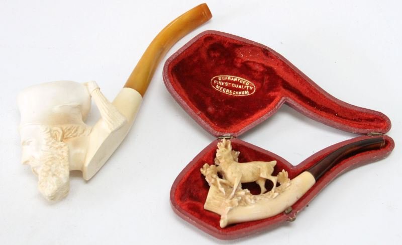 TWO CARVED MEERSCHAUM PIPES 1 MAN 1 STAG DEER: Two carved Meerschaum pipes. One older carved Stag pipe with amber stem in original case (5 inches), and one carved bearded man with scholar's hat and screw-on bakelite stem (7 inches). Both in very g