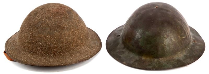 TWO US WWI BRODIE "DOUGHBOY" HELMETS WITH LINERS: Two Brodie helmets. One has an attached rim and "sand" paint finish. The other has a raw rim and worn OD green finish. Both are in good to very good condition. New to the market from the estate of a p