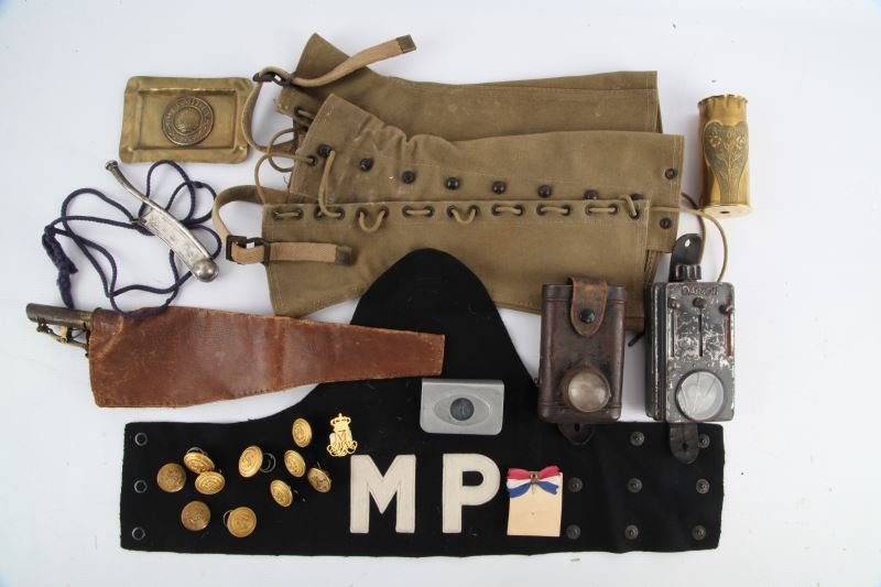 MILITARY COLLECTIBLE LOT BIG VARIETY: Includes trench art shell and ashtray, naval buttons, leather shot pouch, Military Police armband, Bosun's whistle, Damian signal flashlight, antique flash light, and WWII infantry leggings.