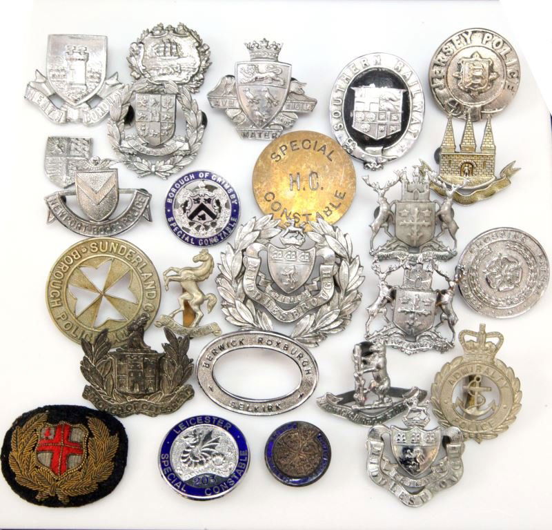 MIXED LOT ENGLISH POLICE BADGES INSIGNIA 20TH C: Mixed lot of 24 obsolete English police badges, pins, one patch. Most cap badges, few lapel badges, most with east-west lugs and rubber mounts to back from display. Different cities and shield insigni
