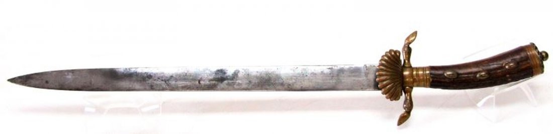 WWII GERMAN STAG HANDLE HUNTSMAN SWORD WITH SHELL: WWII German Huntsman sword. Deer hoof etched brass cross guard with shell. Three raised knobs within stag handle grip. Some pitting and surface marks to blade. Measures 22 inches. Overall good conditi
