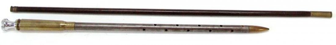 TWO US SWAGGER STICKS 1893 AND NEWER: Included is a 23 inch wooden stick with shell casings on each end. One end has a casing marked "1893 DM K". The other end is worn on end. The other swagger stick has a .50 caliber shell on one end, th