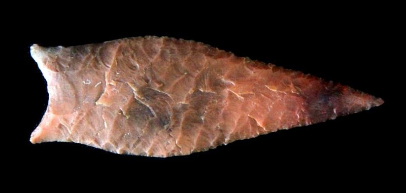 STUNNING MISSOURI PALEO RED SIMPSON ARROWHEAD: Fluted both sides and basal ground, wafer thin, use patina, rich multi hued red chert, deeply imbedded sediment, measures three inches, from a mid west mostly Missouri area collection that dates back 