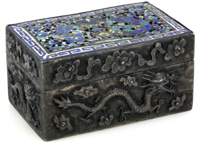 HAND CHASED AND ENAMELED CHINESE SILVER BOX: Intricately chased box in silver adored with dragons on sides and top. Top being pierced and enameled in shades of blue and yellows. Three Chinese hallmarks on bottom of box. Three by two inches by 1.