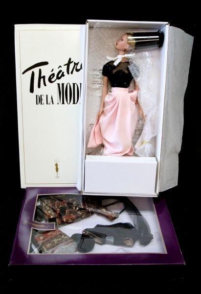 TYLER WENTWORTH COLLECTION DOLL AND OUTFITS: The doll in this lot is a Theatre De La Mode 001 from the Robert Tonner Doll Company. She comes complete with a stand and original wrapping. She is in mint condition with box and measures 16". The ext