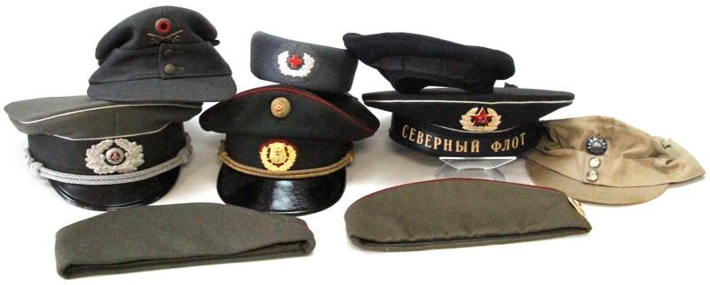 LOT OF 9 MILITARY CAPS FROM VARIOUS COUNTRIES: Included in this lot are visor caps from the Soviet Union, Germany and Austria, a cap from the Red Cross, side caps from the USSR and Slovenia, and more. All of the caps are in very good condition and