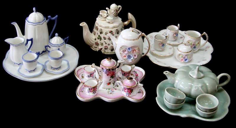 GROUP OF 5 PORCELAIN DOLL TEA SETS WITH LIMOGES: Porcelain doll tea sets, 5 total. Includes: Lefton China set (10-pc) (small chip to pot rim), English Portmeirion set of 4, green pumpkin ceramic set of 6, Limoges floral and gilt pattern (10-pc), and
