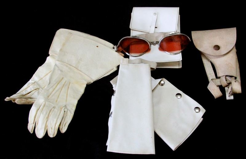 VINTAGE ITALIAN GOGGLES AND ACCOUTREMENTS: Lot of vintage Italian police gear from the World Police Museum in Milan, Italy. This lot contains goggles, white leather gloves, white leather gun holster, a white leather pouch and spats. The goggle