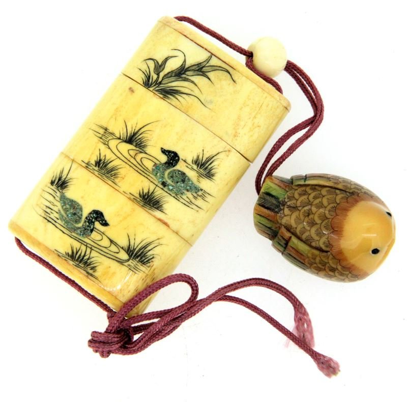 VINTAGE IVORY INRO WITH OJIME AND NUT: Pre-banned ivory Inro, with scrimshaw and inlays comes in three parts. The Netsuke is made out of tagua nut. One side depicts ducks on a lake, and the other depicts naturalia. This item has excellent 