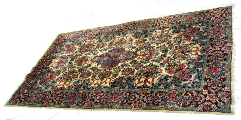 HAND KNOTTED TURKISH WOOL SEMI ANTIQUE AREA RUG: With a variety of blue base hues. Approximately 4 by 7 feet. Floral patterns with reds, pinks and creams. Very good condition. Uncertain of age or origin. 0