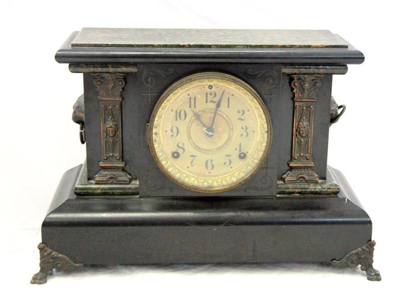 SETH THOMAS ANTIQUE MANTEL CLOCK: Seth Thomas antique wooden mantel clock. The clock has engraved designs, lion head handles, faux marble, and ornate columns. Untested but in overall good condition. 0