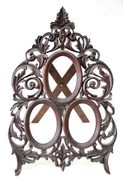 BLACK FOREST CARVED WALNUT TRIPLE PICTURE FRAME: 24 by 16 inches. Heavy intricate carving of scrolling leaf work. Three oval openings 4.25 by 6.25 inches each. With minor losses and repairs. 0
