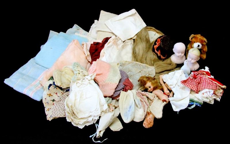 UNSEARCHED DOLL LOT INCLUDING BISQUE HEADS: Lot of unsearched antique and vintage doll parts and clothes. At a glance, the lot includes doll hair and 2 bisque heads, in addition to clothes. 0