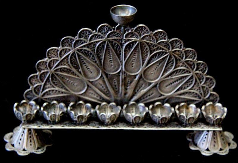 RUSSIAN JUDAIC STERLING SILVER MENORAH: Menorah measures approximately 5 inches in length and is marked "AK, 1879". Light show of age present; overall in very good condition. This lot has a reserve.