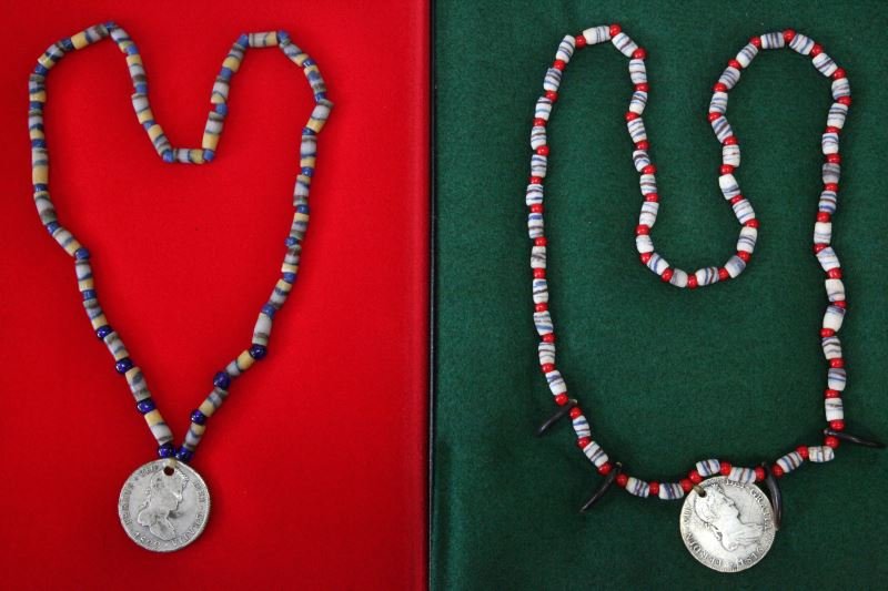 2 EARLY INDIAN TRADE BEAD NECKLACES WITH COIN 1822: Two Early Indian trade bead necklaces. One is made of blue, white, and brown striped beads with red white heart beads and beaver claws (1816 8R Ferdin VII coin), and one is made of multi-color and blu