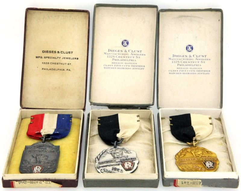 BOXED PENNSYLVANIA RAILROAD 1923 TRACK MEDALS: All three are dated 1923 and carry the PRR logo in enamel. All are in there original boxes. There is a Gold medal (Gold Filled) for the Eastern Region Championship Girls 50 yard, and a Silver (Sterlin