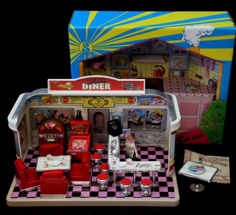 EPOCH DIXIE'S DINER FULL SET & GERMAN DOLL KITCHEN: Mixed collectable doll house lot. Includes a German (still in box) model open kitchen (made of aluminum, painted), and 1988 Epoch Co. Dixie's Diner (all furniture and doll). Very good condition.