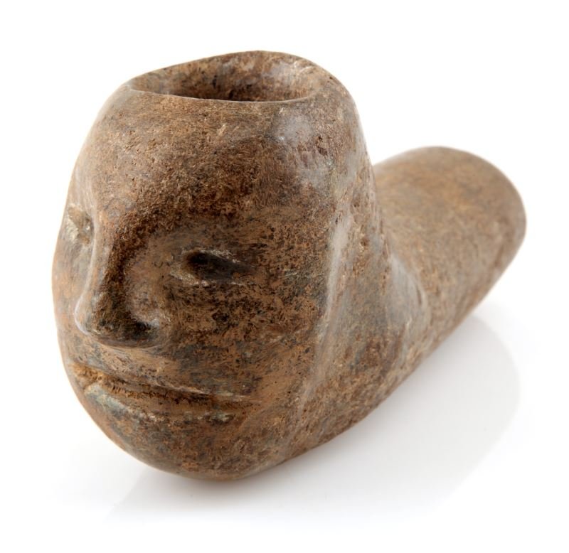 NATIVE AMERICAN STONE PIPE WITH FACE: Polished stone pipe with a carved human face on the bowl. Writing on the bottom of the stem suggests it was found in Sullivan County Tennessee. Similar pipes have been found in Tennessee mounds. The f