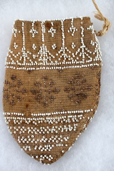 SMALL ART DECO ANTIQUE BEADED DRAWSTRING POUCH: Small beaded Art Deco pouch with white and brown beads. The pouch is decorated with snowflakes and geometric patterns on a tan background. The pouch has some stains and damage to the beading but overa