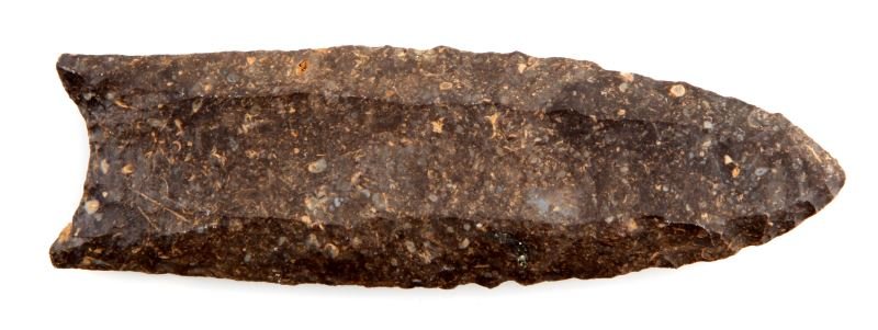 NATIVE AMERICAN PALEO CLOVIS ARROWHEAD POINT: Paleo Clovis point. Darker grey to black stone, with lighter inclusions of quartz. Parallel flaking, bifacial fluting (one running the length of the blade), concave base, measures 3.5 inches. Little s