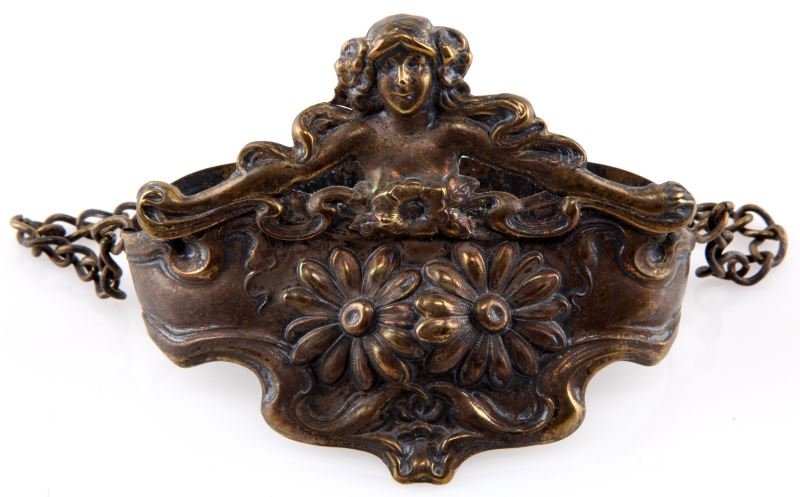 ANTIQUE ART NOUVEAU WHISK BROOM HOLDER: Antique chatelaine whisk broom holder with Art Nouveau decorations. The item has a young woman with flowing hair and flowers. 3 inches by 4.5 inches. In very good condition.