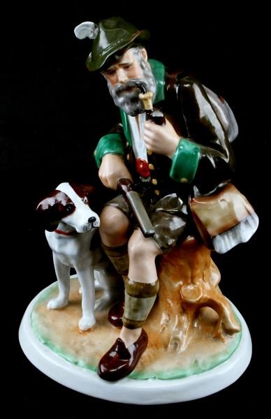 PORCELAIN FIGURINE BAVARIAN SEATED HUNTER & DOG: Hand painted porcelain figurine of a Bavarian hunter seated smoking a pipe with his dog seated beside him. Bottom has "17415" pressed into porcelain and a overglaze stamp of an S intersected by a back