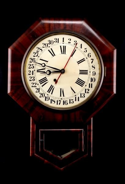 ANTIQUE CHERRY SCHOOL CLOCK 31 DAY INDICATOR: Measuring 25 inches tall, 17 1/4 inches wide and 5 1/2 inches thick, very nice cherry veneer school clock, still working. Key wind, white dial with roman numerals, plus outer 31 day "red hand" indicat