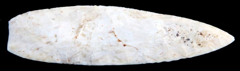 AGATE BASIN ARROWHEAD POINT TRANSITIONAL PALEO IL.: Transitional Paleo Agate Basin point, Illinois. Well worn patina with flea-bite chip to tip exposing whiter stone. Random and parallel flaking with a ground base. Almost 4.5 inches long. Very good con