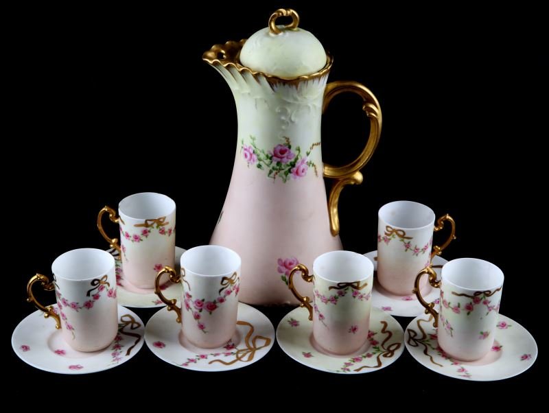 J.P. LIMOGES ANTIQUE 1901 CHOCOLATE SET: Antique hand painted Jean Pouyat Limoges chocolate set. Includes chocolate pot, 6 cups, and 6 saucers. The chocolate pot is painted pink and green with gold gilding and rosettes. The pot is lidded and