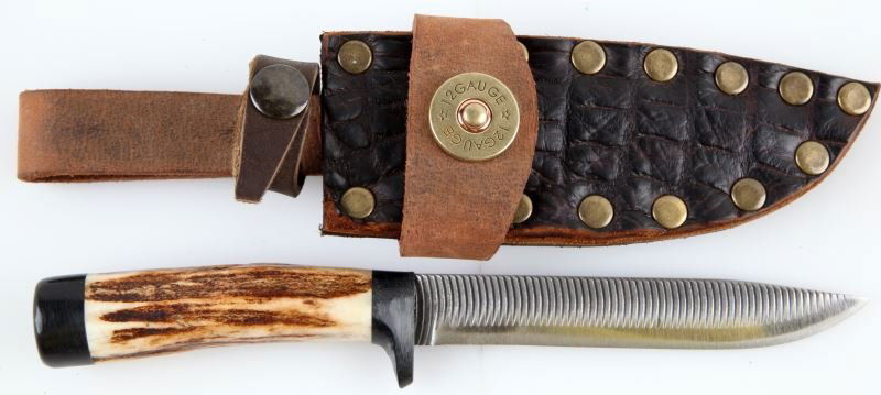 4 3/4 INCH HANDMADE KNIFE W ANTLER HANDLE & SHEATH: Handmade 4 3/4 inch steel blade knife with antler handle and black leather sheath. Sheath contains belt loop and 12 gauge firing cap emblem. Overall very good condition. 0
