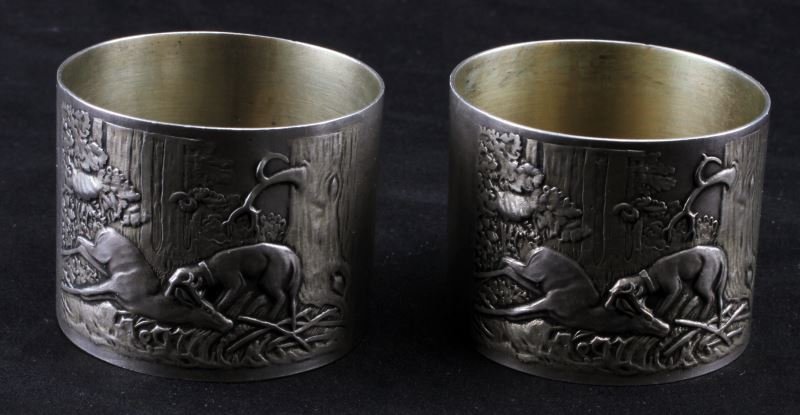 ANTIQUE RUSSIAN SILVER HUNTING NAPKIN RINGS MOSCOW: Two matching napkin rings made between 1908-1926 in Moscow. The rings are hallmarked and are .875 parts silver. The rings depict a hunt scene, showing a dog capturing a deer. Both rings are monogramme