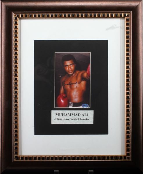 AUTHENTIC SIGNED MUHAMMAD ALI FRAMED PHOTO: Authentic signed Muhammad Ali photograph with holographic sticker. Below the photograph it reads "Muhammad Ali 3-Time Heavyweight (sic) Champion". The holographic sticker with number A204404. Framed p