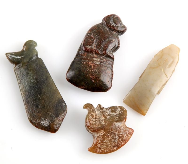 ANTIQUE CHINESE HAND CARVED JADE SM. AXE PENDANTS: Includes 4 varying pieces of carved Jade axes. Lighter yellow jade to darker green and red. Animal or face figure to top, some incisions outlining features. All under 3.5 inches long. All have perfora