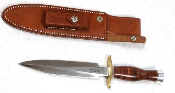 RANDALL MADE 2 7 KNIFE WITH SCABBARD: Randall knife with 7 inch blade. "RANDALL MADE ORLANDO, FLA." appears on base of blade near hand guard. Wooden handle. "2 7 RANDALL MADE KNIVES ORLANDO, FLA." etched into back of leather sheath. Whet 
