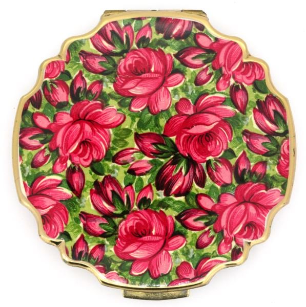 VINTAGE STRATTON COMPACT NEVER USED W SLEEVE: Vintage Stratton compact made in England. The compact has a red and green floral design painted on the lid, the bottom has in impressed star design. When opened, the top has a circular mirror and the 