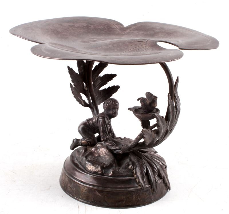 MERIDEN SILVER PLATE ANTIQUE FOOTED COMPOTE: Antique silver plate footed compote by Meriden Silver Plate co. The plate is a large wide lily pad held by leaves and branches. Beneath the lily pad is a young boy watching a birds nest. Lovely piece,